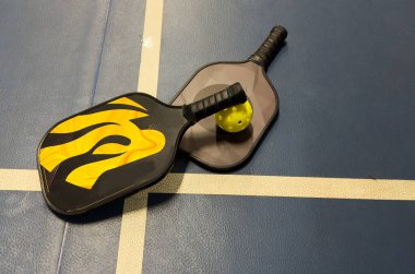 Pickleball tennis racket on the court. Blue background with copy space. Sport court and ball. High quality photo clipart