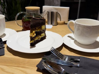 Ahşap masa arkasında beyaz tabakta nefis çikolatalı pasta, yakın plan. Yüksek kalite fotoğraf