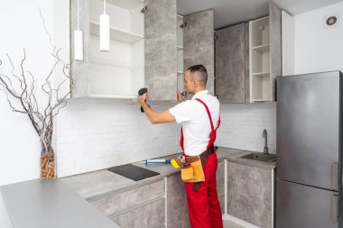 Mutfak tesisatçısı. Mobilya dolabı menteşesi monte eden bir işçi. Yüksek kalite fotoğraf