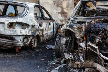 Broken and burned cars in the parking lot, accident or deliberate vandalism. Burnt car. Consequences of a car accident. Damaged by arson. Dump of civilian vehicles shot by Russian troops in Ukraine clipart