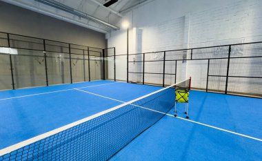  İnternetteki padel Court 'ta. Mavi sahada tenis ağıyla oynanan aktif bir maç ve insan yok. Yüksek kalite fotoğraf