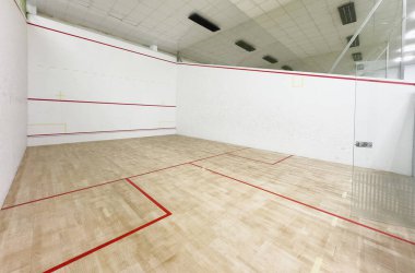 Beyaz duvarları ve cilalı zemini olan modern squash kortu motivasyon ve kararlılık konsepti. Yüksek kalite fotoğraf