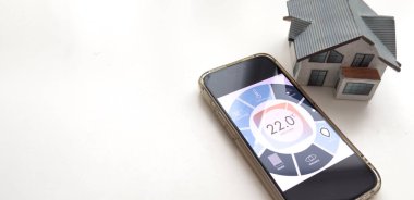 Akıllı bir evle ev ısısını kontrol etmek, telefonla yakın çekim yapmak. Evdeki akıllı cihazları yönetmek için akıllı ev ve mobil uygulama kavramı. Yüksek kalite fotoğraf