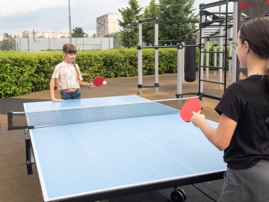 Mutlu kız arkadaşlar masa tenisi oynuyorlar, birlikte eğleniyorlar. Yüksek kalite fotoğraf