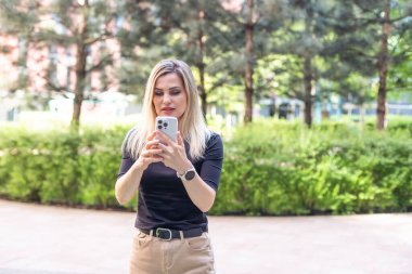 Güzel sarışın kadın akıllı telefondan mesaj atıyor. Yüksek kalite fotoğraf