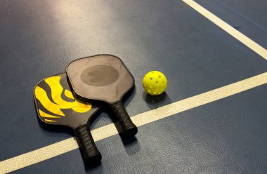 Pickleball tennis racket on the court. Blue background with copy space. Sport court and ball. High quality photo clipart