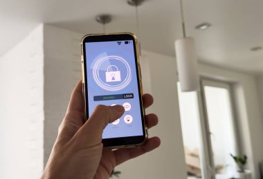 Akıllı ev, ev otomasyonu, uygulama simgeli aygıt. Adam akıllı telefonunu akıllı güvenlik uygulaması ile evinin kapısını açmak için kullanıyor. Yüksek kalite fotoğraf