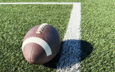 Sahada bir Amerikan futbolu yakın plan, arkada oyuncular. Yüksek kalite fotoğraf