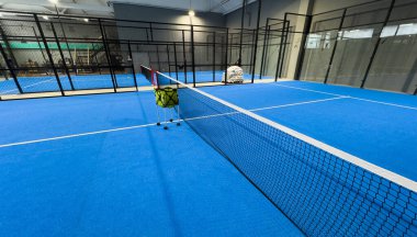  İnternetteki padel Court 'ta. Mavi sahada tenis ağıyla oynanan aktif bir maç ve insan yok. Yüksek kalite fotoğraf