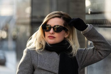 Paltolu kız güneşli bir günde şehirde dolaşır. Yüksek kalite fotoğraf