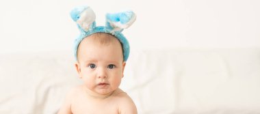 Paskalya tavşanı kulaklarında giyinmiş kadar şirin bir bebek portresi.