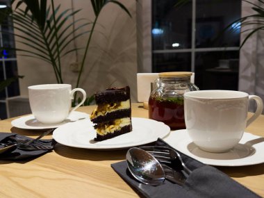 Ahşap masa arkasında beyaz tabakta nefis çikolatalı pasta, yakın plan. Yüksek kalite fotoğraf