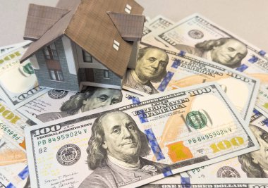 Amerikan doları banknotlarının arka planında ev modeli. Konut piyasası, emlak satın alma veya kiralama kavramı. Yüksek kalite fotoğraf