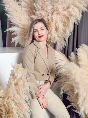 Sakinleşen genç hippi kadın şık bir İskandinav bahçesinde egzotik bitkilerle oturuyor. Çiçekçi kız, ev serasında çiçekçiyle vakit geçirmekten hoşlanıyor. Yüksek kalite fotoğraf