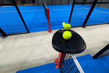 Padel raketi mavi bir kortta top ile. Yüksek kalite fotoğraf