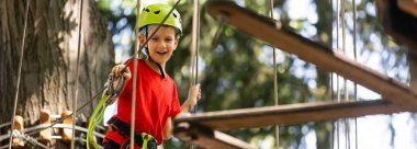 Aktif çocuk eğlencesi. İp parkına tırmanıyorum. Yüksek kalite fotoğraf
