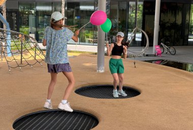 Bir yaz gününde trambolinde zıplayan iki kız. Yüksek kalite fotoğraf