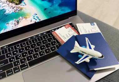 seyahat ve tatil konsepti. Uçak, uçak, dizüstü bilgisayar, pasaport ve biletler masanın üstünde. Yüksek kalite fotoğraf