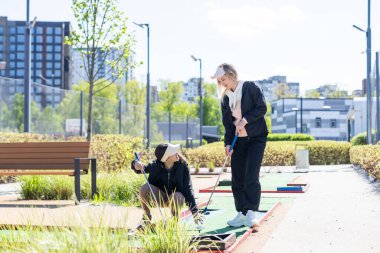 Küçük kız ve anne mini golf oynuyorlar. Yüksek kalite fotoğraf