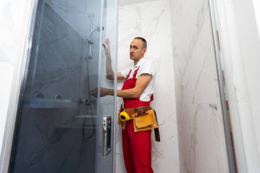 İçerideki plastik pencereyi ölçen bir işçi. Kurulum süreci. Yüksek kalite fotoğraf