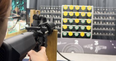 Genç bir kız silahla atış talimi yapıyor. Yüksek kalite fotoğraf