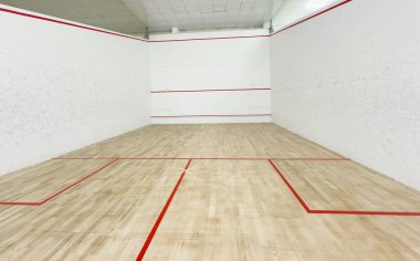 Beyaz duvarları ve cilalı zemini olan modern squash kortu motivasyon ve kararlılık konsepti. Yüksek kalite fotoğraf