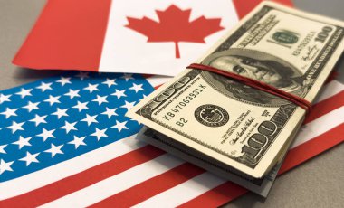 Ekonomik ilişkileri simgeleyen dolar banknotlarını kaplayan Kanada bayrakları. Yüksek kalite fotoğraf