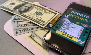 İş ve spor konsepti. Dolar banknotları üzerine bahis uygulamalı akıllı telefon. Yüksek kalite fotoğraf