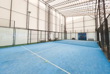 Boş raket tenis kortu, kapalı bir barakanın ışıkları açık ve oyuncuları yok. Yüksek kalite fotoğraf