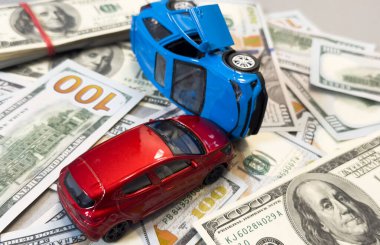 100 dolarlık banknotların arka planında kazara oyuncak arabalar. Yüksek kalite fotoğraf