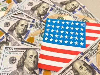  100 dolarlık banknot ve Amerikan bayrağının arka planında duran bir evin koşullu görüntüsü. Yüksek kalite fotoğraf