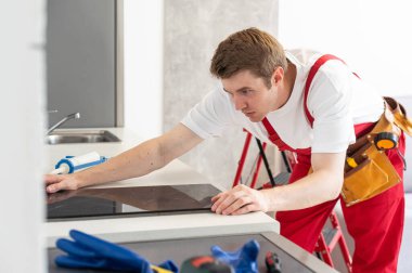 Eldiven ustası mutfağa çadır kuruyor. Ev Aletleri Kurulum Hizmetleri Konsepti.