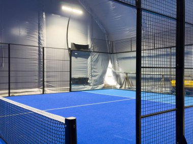  Geniş modern bir yapı altında, yeni kurulmuş padel kortları. Merkezde mahkemelerin girişi var, bir tarafta. Yüksek kalite fotoğraf