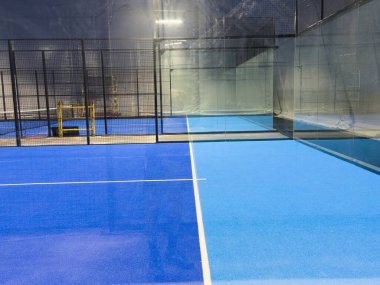  Geniş modern bir yapı altında, yeni kurulmuş padel kortları. Merkezde mahkemelerin girişi var, bir tarafta. Yüksek kalite fotoğraf