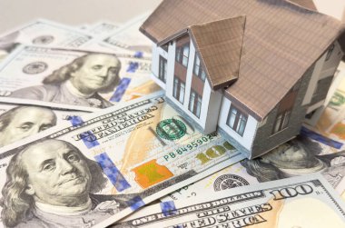 Amerikan doları banknotlarının arka planında ev modeli. Konut piyasası, emlak satın alma veya kiralama kavramı. Yüksek kalite fotoğraf