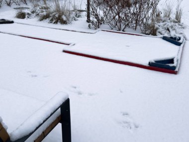  snow-covered mini-golf course with colorful obstacles and a large chess piece-like structure, with a wintry background. High quality photo clipart