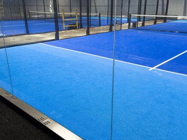  Mavi kort Padel için örgü ve cam arka duvarların oluşturduğu bir yapı. Yüksek kalite fotoğraf