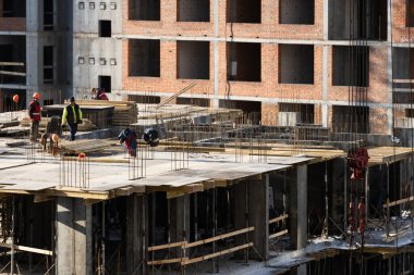 İnşaat mühendisi ekibi standart güvenlik üniforması içinde inşaat alanında çalışıyor. Yüksek kalite fotoğraf