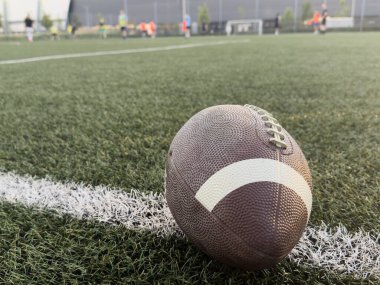 Sahadaki çimen futbol sahasında oturan Amerikan futbolunun yukarıdan görünüşü. Genel spor imajı. Yüksek kalite fotoğraf