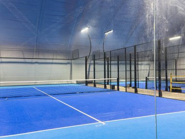  Geniş modern bir yapı altında, yeni kurulmuş padel kortları. Merkezde mahkemelerin girişi var, bir tarafta. Yüksek kalite fotoğraf