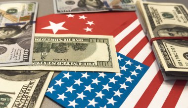 Us and china flags with currency symbolizing economic relations. High quality photo clipart