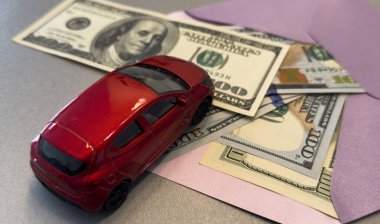 100 dolarlık banknotların arka planında oyuncak araba. Yüksek kalite fotoğraf