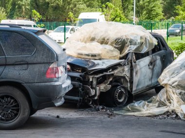 Otoparkta kırık ve yanmış arabalar, kaza ya da kasıtlı vandalizm. Yanmış araba. Bir araba kazasının sonuçları. Kundaklama yüzünden zarar görmüş. Rus birlikleri tarafından Ukrayna 'da vurulan sivil araçlar.