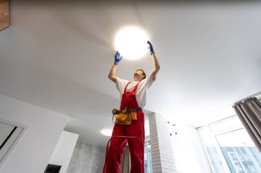 Yeni evin tavan lambasını değiştiren adam..