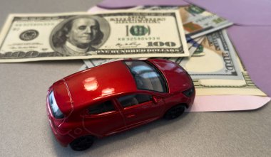 100 dolarlık banknotların arka planında oyuncak araba. Yüksek kalite fotoğraf