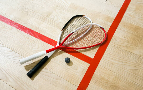 Squash rackets and ball on court floor, top view. High quality photo