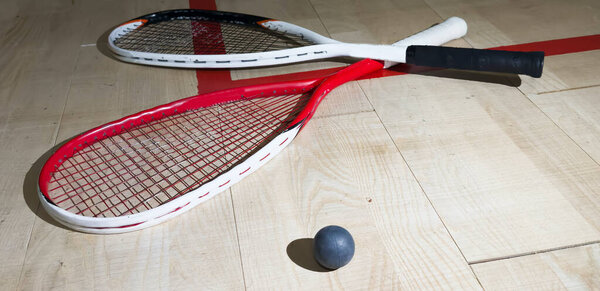 Squash rackets and ball on court floor, top view. High quality photo