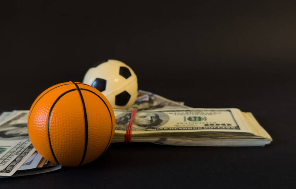 Basketball on a pile of cash -- money and betting in sports concept . High quality photo