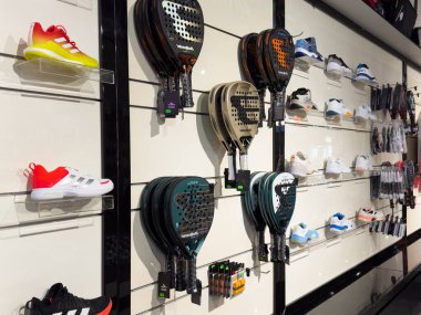 17 Kasım 2024 Kyiv, Ukrayna: Giyim ve spor malzemeleri mağazalarında satılmak üzere raflarda çeşitli türde ve markalarda sergilenen çok renkli padel raketleri. Yüksek kalite fotoğraf