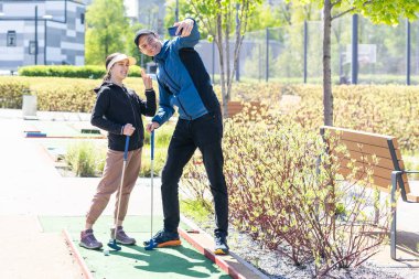 Genç ve yakışıklı bir baba küçük kızına golf oynamayı öğretiyor. Yüksek kalite fotoğraf